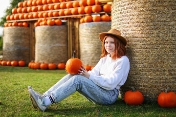Preteen Girl Wearing Hat Portrait at the Pumpkin Patch in a Rustic Setting.
