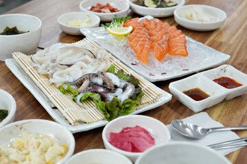 연어 회와 오징어 회가 식탁 위에 놓여 있는 모습