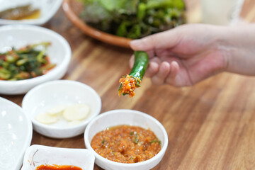 푹 고추를 쌈장에 찍어 먹는 모습