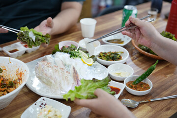 회를 쌈 싸서 먹는 모습