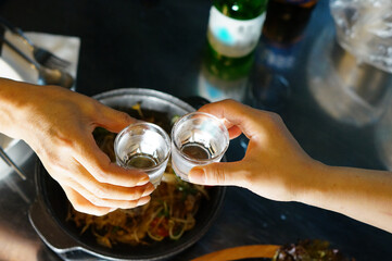 소주 잔으로 두 사람이 건배하는 모습