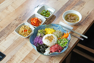 식탁 위에 놓여진 오색 비빔밥을 맛있게 먹는 모습