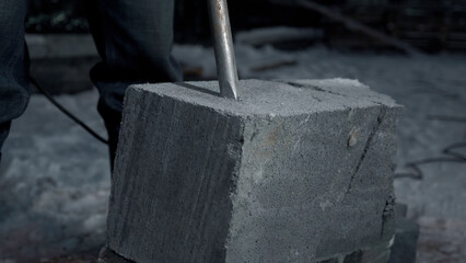 Close up of drilling a cement block. Clip. Industrial works at the construction site.