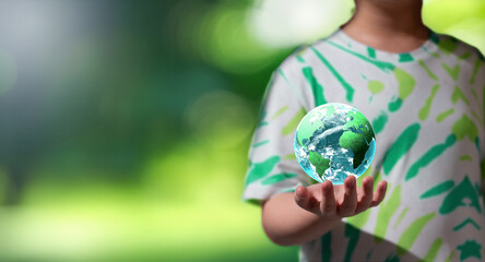 kid hold green globe on blur nature background