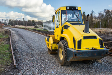 yellow road roller, newly built railway line, gravel embankment, construction works, reconstruction of the railway line