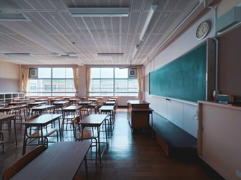 Typical Japanese classroom with desks and chairs, a platform, and a blackboard.