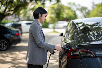 A woman is charging her electric car