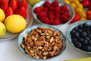 Apples, lemons, bananas, berries, carrots, leek, tomatoes, radishes, spinach and various nuts on white background. Healthy seasonal fruit and vegetable. Selective focus. © jelena990