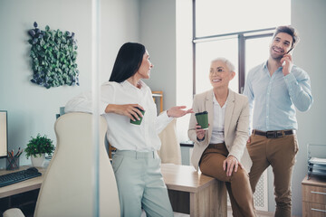 Photo of business people women talking with takeaway cup in workplace workstation