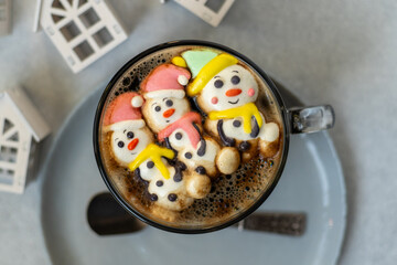 Cup of coffee with marshmallows. Marshmallow snowman in a Santa Claus hat. Winter drink. Christmas sweet food. Top view.