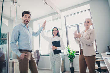 Obraz premium Photo of business people feel happiness celebrate victory doing highfive in workplace