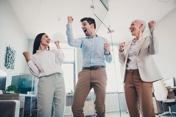 Photo of business people raise fists up winning scream in workstation