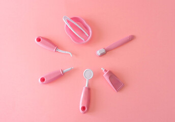 top view of A pink set of dental toy tools for infant dental care on pink background