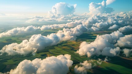 Aerial view of billowing clouds casting shadows over a patchwork landscape, creating a stunning natural tapestry.