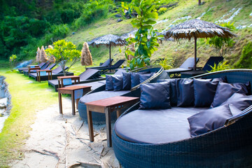 Round sun loungers on the beach area of the hotel by the sea. Sun loungers by the pool with tables...