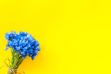 Summer design for blog with bouquet of blue cornflowers on yello