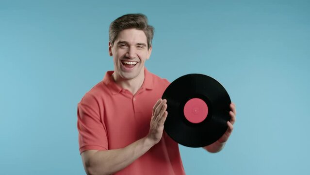 Stylish mature man with vinyl record disc on blue. Hobby, music lover, collection, nostalgia lifestyle