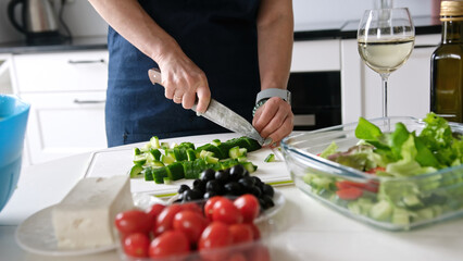 Woman'S Hands Are Slicing Cucumber For Greek Salad With A Glass Of White Wine Nearby