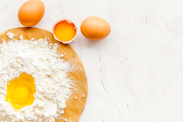 Making dough concept. Pile of flour and eggs on white background top view space for text