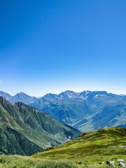 A panoramic view of a mountain range with a clear blue sky, perfect for themes of adventure and natural beauty