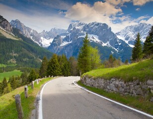 Fototapeta premium transport road in the Alps against the backdrop of snow-capped mountains and forest