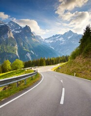 Naklejka premium transport road in the Alps against the backdrop of snow-capped mountains and forest