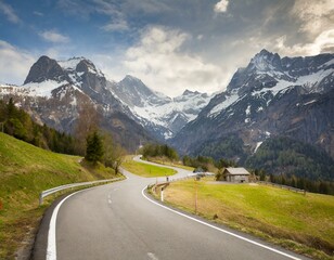 Fototapeta premium transport road in the Alps against the backdrop of snow-capped mountains and forest