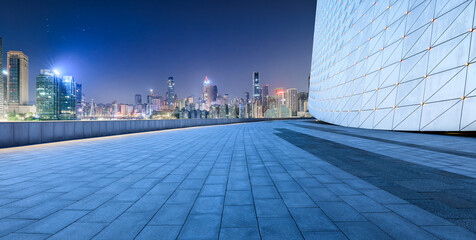 Empty square floor and brick wall with modern city buildings at night in Chongqing. panoramic view.
