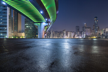 Asphalt road and bridge with modern city buildings at night 