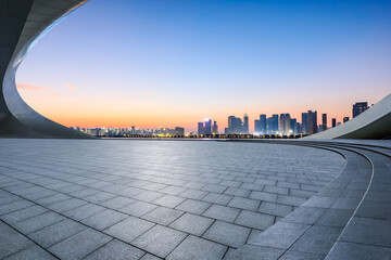Empty square floor and city skyline with modern buildings at sunrise
