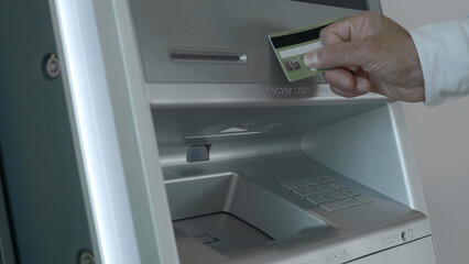 Close-up of man withdrawing money from ATM. Media. Modern ATMs with contactless money withdrawal. Man puts card to terminal and withdraws money