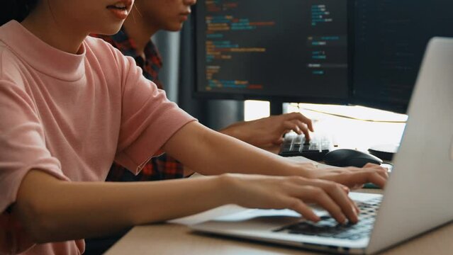 Slow motion back end software developer engineer for computer programming working together on debugging writing computing code, solving complex algorithms display on monitor in office. Burgeoning
