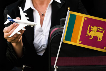 business woman holds toy plane travel bag and flag of Sri Lanka