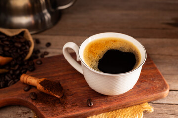 Black coffee with white cup and roasted coffee beans brown sugar and a cup of hot espresso coffee flat top view on a dark background