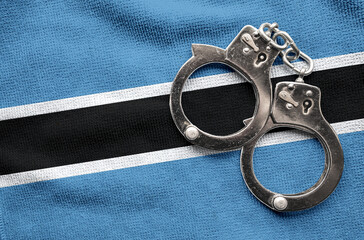 Flag of Botswana and police handcuffs. Crime and offenses in country Concept	
