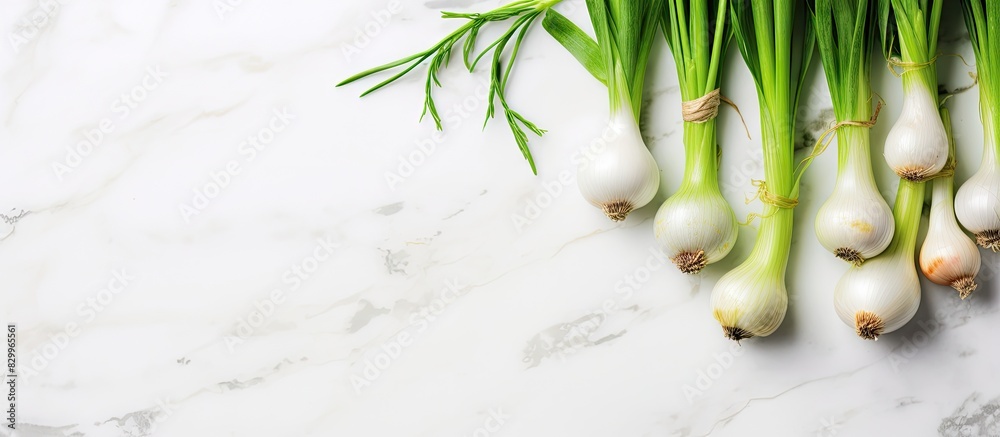 Aufkleber a cluster of fresh green spring onions arranged on a white marble surface captured from above this f