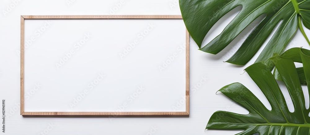Poster A gray background with a monstera leaf and an empty photo frame mockup Flat lay top view with copy space for text or images