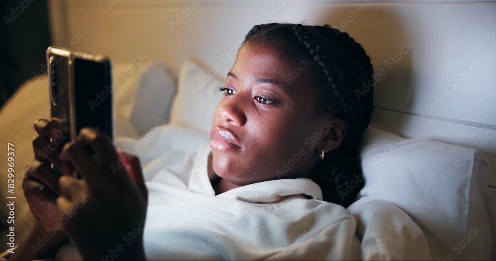 Sticker Night, typing and black woman with phone on bed for online chat, communication and networking. Resting, home and tired person on smartphone for social media, website and internet news in bedroom