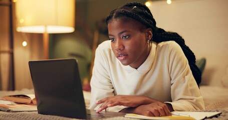 Education, laptop and night with black woman on bed in home for distance learning or remote study. Computer, evening research and notebook with college or university person in bedroom of apartment
