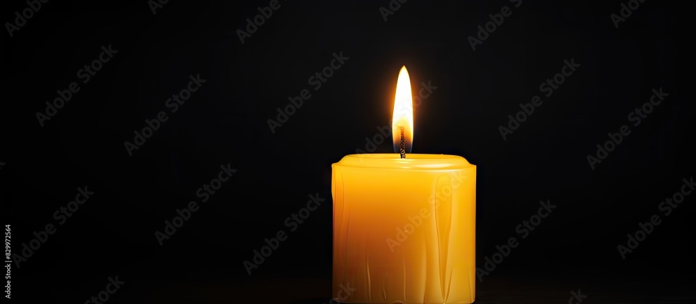 Poster a burning yellow candle is seen up close against a dark background providing room for additional tex