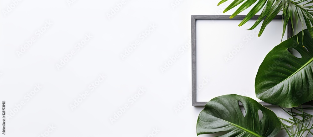 Poster A gray background with a monstera leaf and an empty photo frame mockup Flat lay top view with copy space for text or images