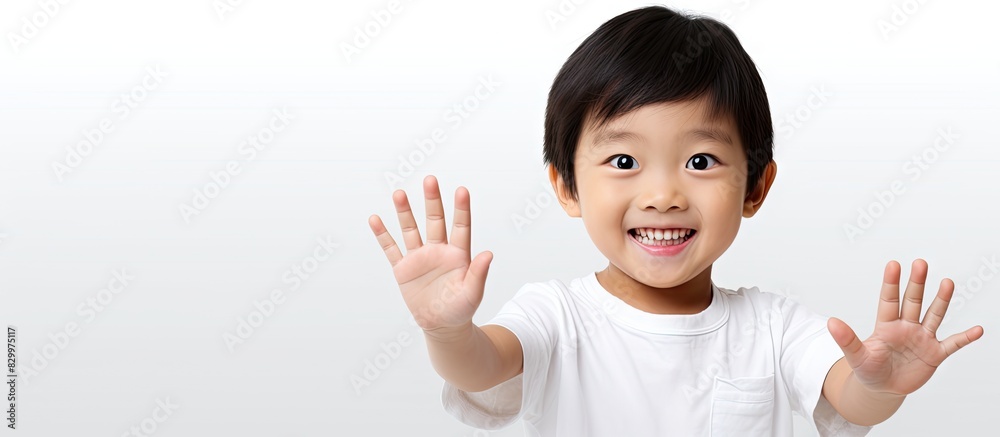 Poster A happy and attractive Asian child showcasing an area for text or images on their open palm against a plain white backdrop. with copy space image. Place for adding text or design
