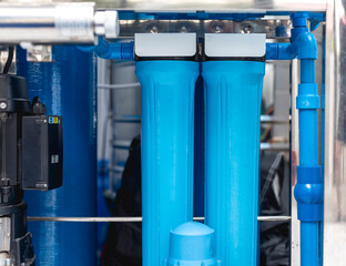 Water refilling station equipment showcasing blue filtration tanks and pipes, emphasizing clean...