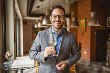 Adult man stand in a winery and hold glass of wine