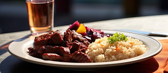A plate of fried meat with rice accompanied by a stew of meat vegetables and a glass of beet juice Copy space image