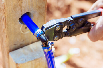 Plumber connects blue PVC pipe to water piping system