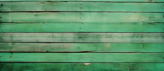 An old vintage green wooden fence serves as a close up copy space image with textured wall panels or floor planks providing a natural and abstract background for text