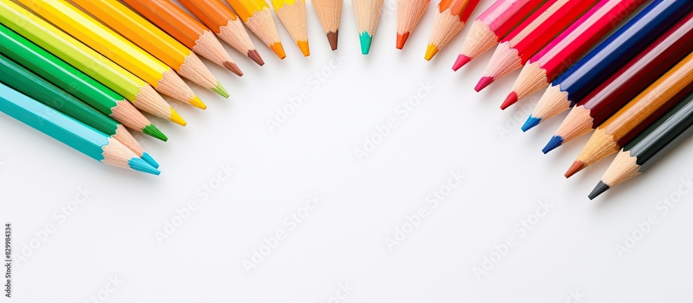 Poster A close up image of color pencils arranged in a round formation on a white background with the composition centered at the upper left creating copy space
