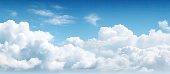 Daytime sky with a subtle haze and fluffy white clouds offering plenty of empty space for creative copy or images