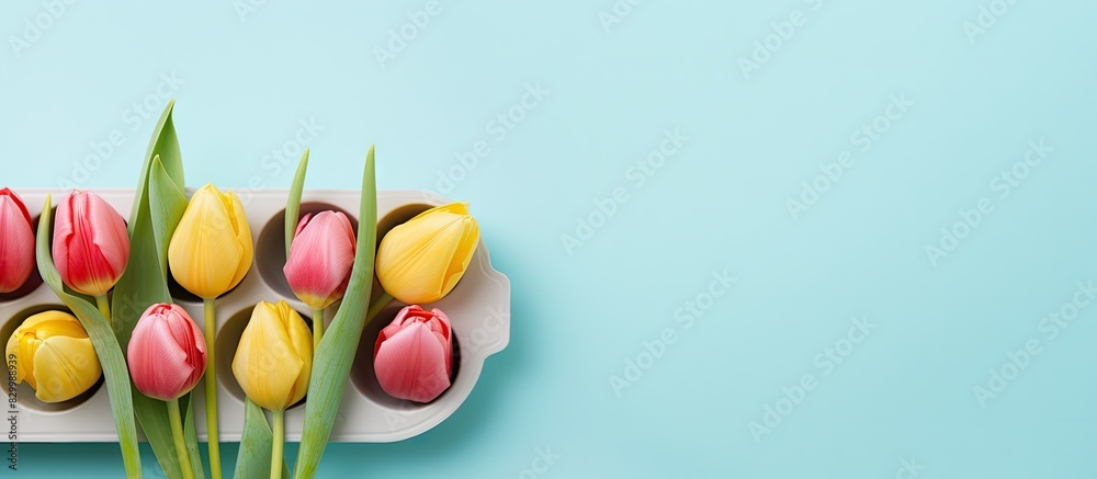 Poster a colorful easter egg tray adorned with tulips sits on a pastel blue and yellow background creating 